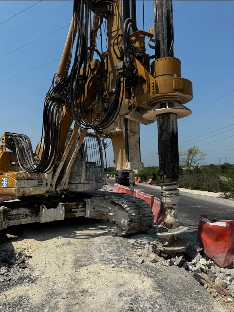 Expofer · Tramo 5, Frente 2 · detalle de la perforadora y herramienta helicoidal junto a las barreras de protección vial